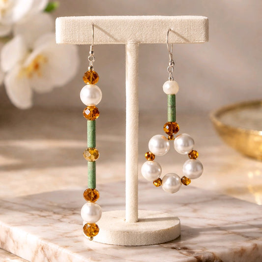 Earrings on a T bar with flowers in the background.