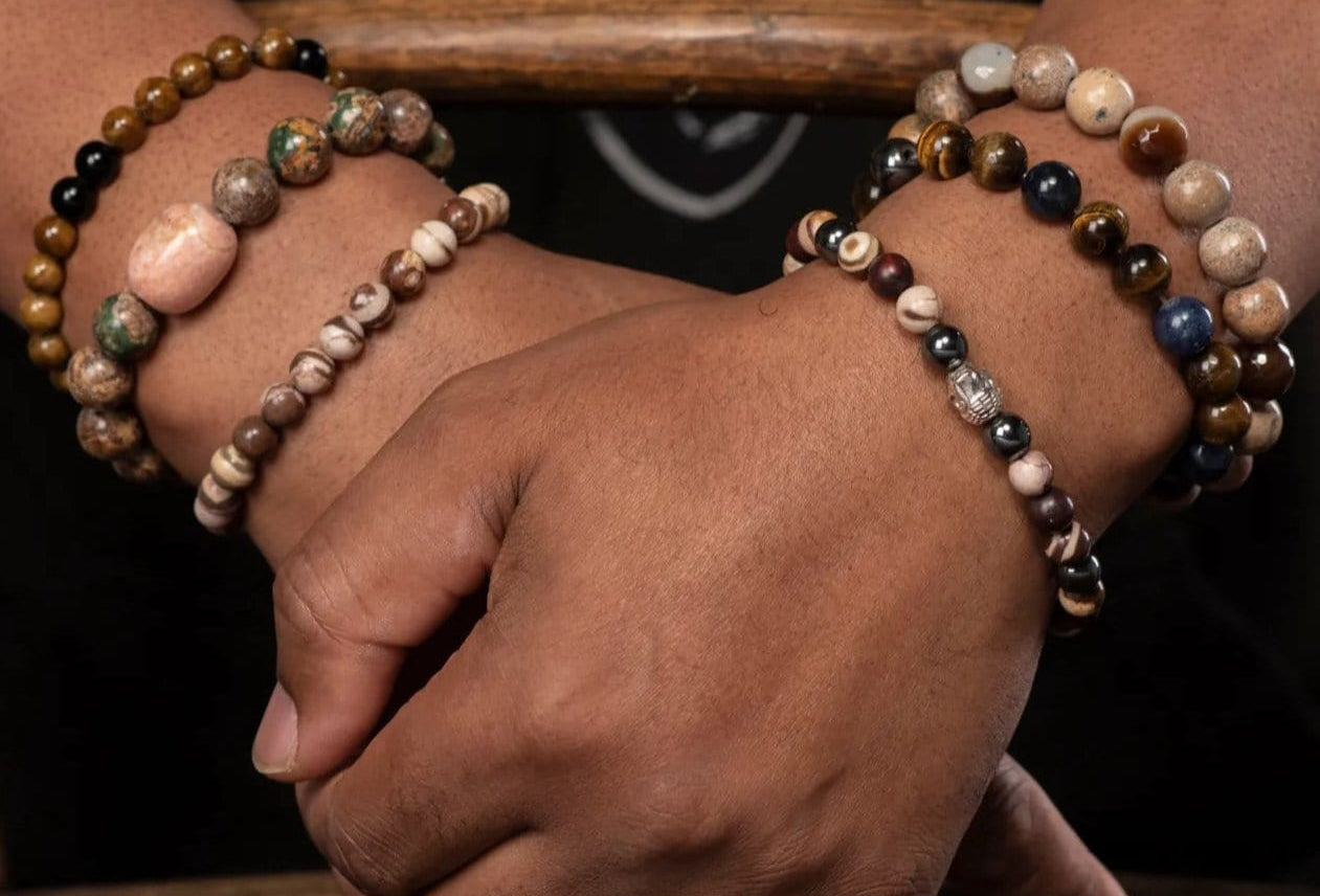 Man wearing a range of handmade, semi precious bracelets