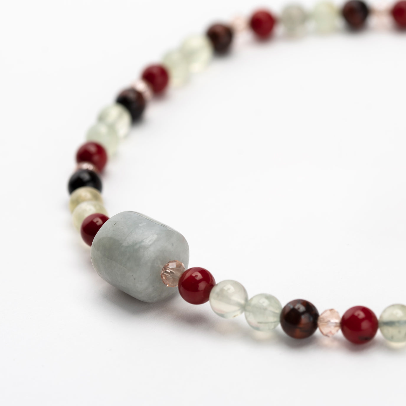 Beaded necklace with gray, red, and white beads on a white background.