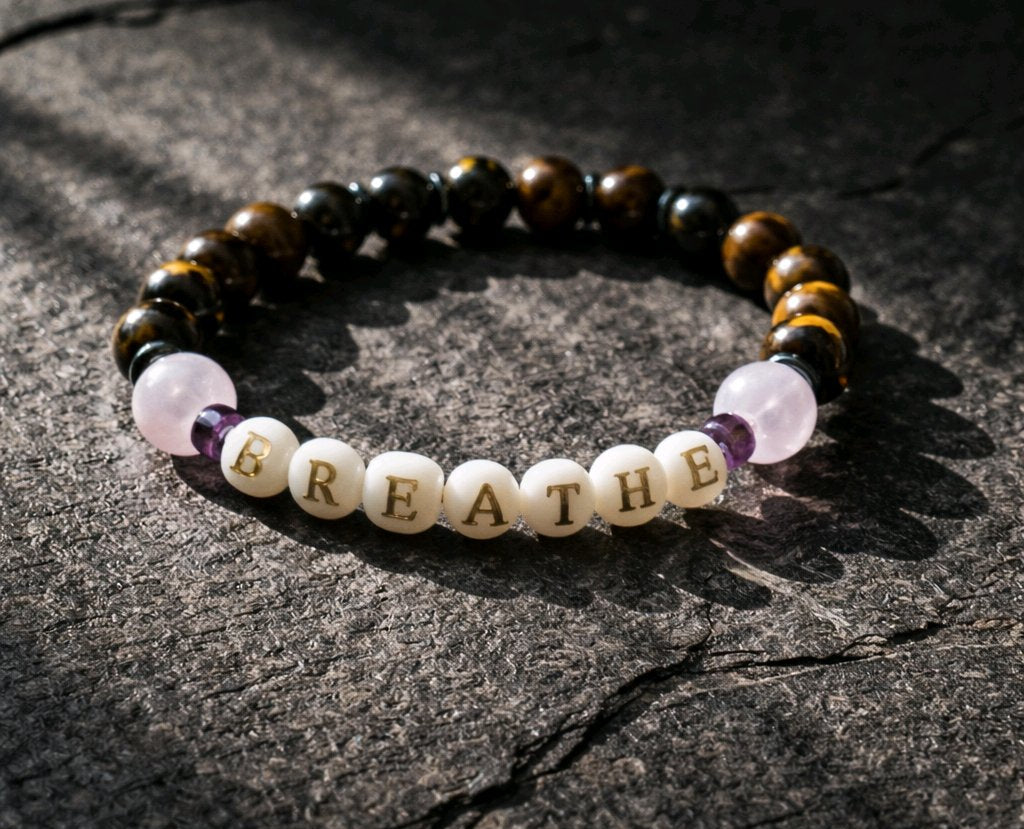 A bracelet with the word BREATHE on a stone background.
