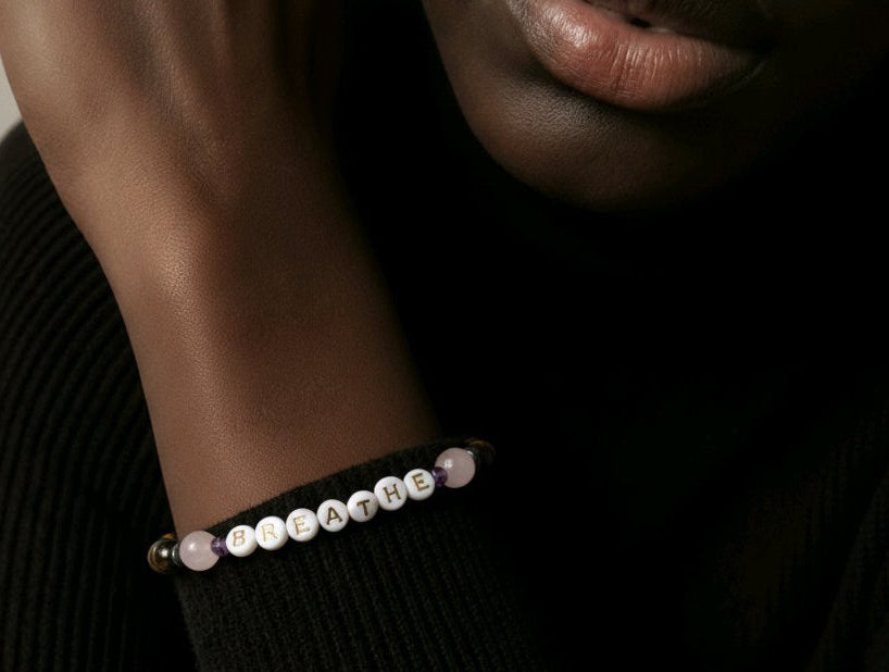 Man wearing a bracelet that says the word breathe.