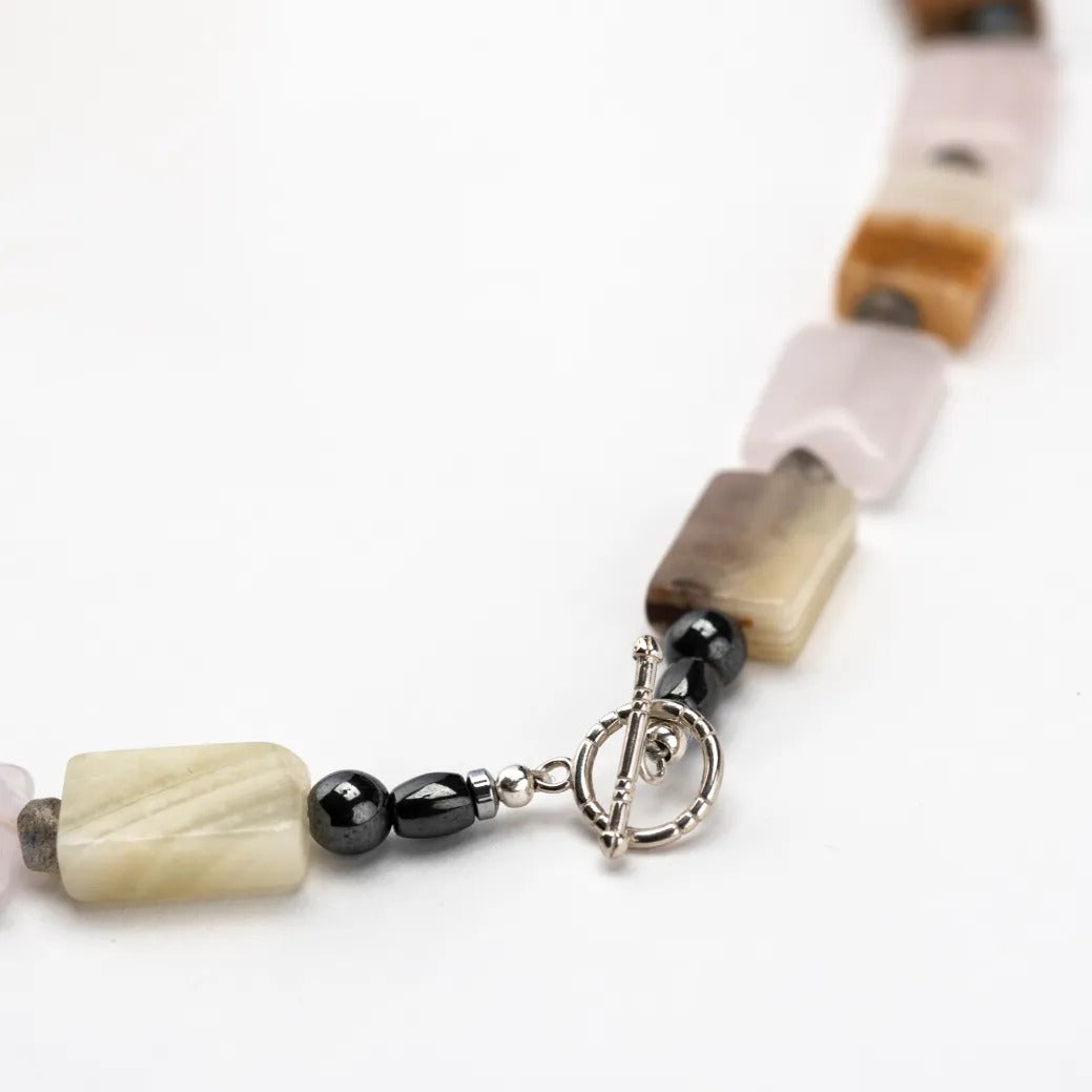 Video showing a model wearing rose quartz earrings and the rose quartz onyx necklace.
