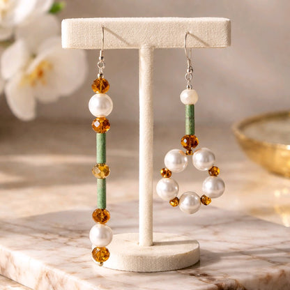 Earrings on a T bar with flowers in the background.
